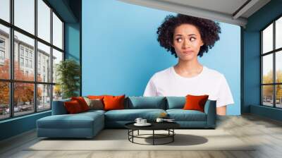 Portrait of young unhappy upset thoughtful minded afro girl look copyspace thinking isolated on blue color background Wall mural