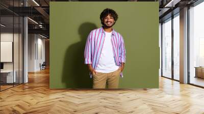 Portrait photo of candid arab businessman in striped casual shirt and eyeglass posing confident isolated on khaki color background Wall mural