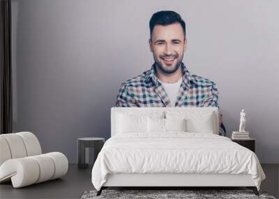 Portrait with copy space of young attractive, stunning, smiling man having his hands crossed, looking at camera, standing over grey background Wall mural