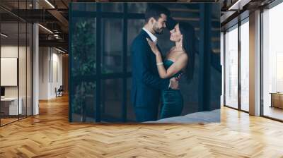 Profile photo of two famous trendy people couple rich guy and lady standing close looking eyes happily smiling romance date wear classy formalwear suit dress loft indoors Wall mural