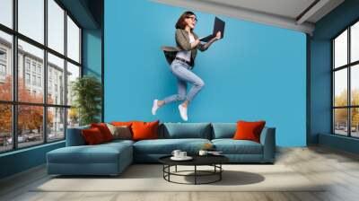 Profile side full size photo of excited lady ceo jump chatting netbook ap wear denim isolated over blue color background Wall mural