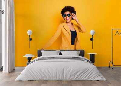 Profile side photo of charming positive cheerful dark skin lady touch her eyeglasses have free time go walk wear stylish clothes isolated over yellow bright color background Wall mural