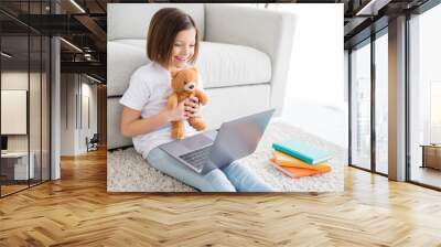 Profile side photo of young cheerful little girl happy positive smile speak talk video call laptop show teddy bear indoors Wall mural