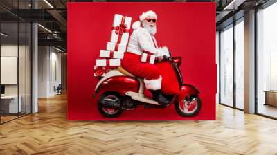 Profile side view of nice bearded cheerful fat funky Santa riding moped carrying pile stack fairy purchases shopping discount isolated on bright vivid shine vibrant red color background Wall mural