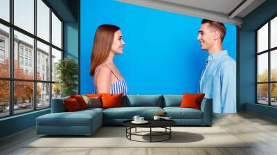 Profile side view portrait of her she his he two nice attractive charming lovely content cheerful cheery people looking at each other isolated over bright vivid shine vibrant blue color background Wall mural