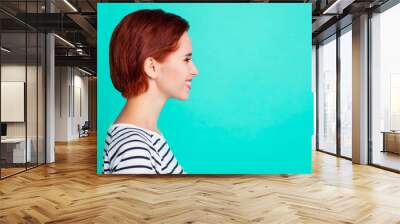 Profile side view portrait of her she nice charming pretty sweet attractive cheerful cheery red-haired lady wearing striped pullover isolated over bright vivid shine green turquoise background Wall mural