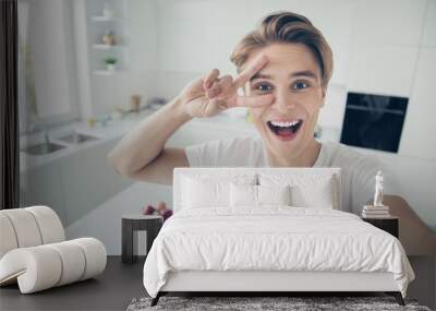 Self-portrait of his he nice attractive cheerful glad cheery optimistic funky guy showing v-sign having fun at light white modern style interior hotel indoors Wall mural