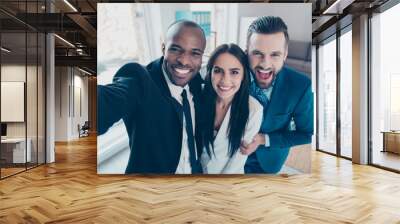 Self portrait of stylish successful, professional trio, afro-american black man with stubble shooting selfie with hand on smart phone with friends, together standing in work place, station Wall mural