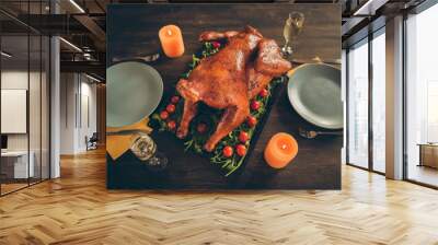 Top above high angle photo of big tasty roast chicken on tray with red cherry tomato herbs served table for two people couple celebrate thanksgiving have plates knifes forks candles glass isolated Wall mural