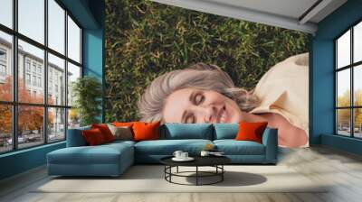 Top above high angle view photo of attractive mature woman enjoy lying green grass dream sleep rest outdoors Wall mural