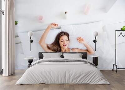 Top view portrait of cheerful positive woman waking up enjoying bed time in the morning keeping eyes closed health healthy Wall mural