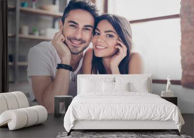 True love. Happy beautiful married couple is chilling out lying on the carpet at the floor at home indoors, looking at the camera and smiling Wall mural