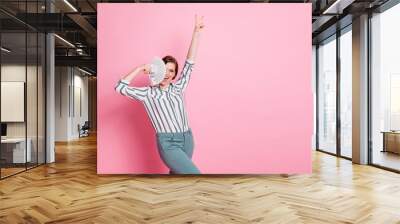 Yeah i millionaire. Delighted positive girl cool she win lottery casino dollars cover face money fan scream show v-sign wear white striped shirt pants trousers isolated pink color background Wall mural