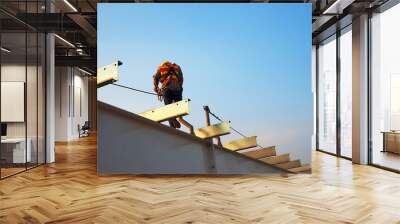 Man Working on the Working at height on construction site with blue sky Wall mural