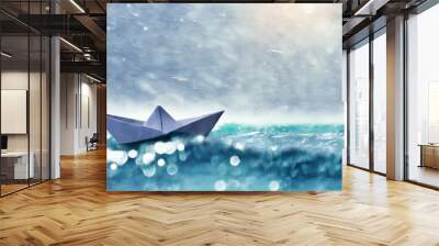 origami ship sailing through rain wind and wave surviving tough time business resilience or life resilience concept Wall mural