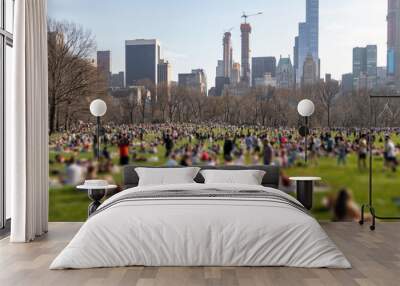 Blurred crowds of people relaxing on the lawn in Central Park on a sunny day in New York City Wall mural