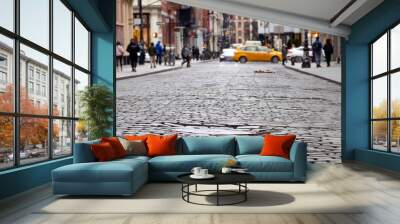 Cobblestone street view of the busy intersection of Broome and Greene Streets with people and taxi in the SoHo neighborhood of Manhattan in New York City Wall mural