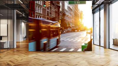 New York City bus driving through the intersection of 23rd Street and 5th Avenue in Manhattan with the light of sunset shining between the skyline buildings Wall mural