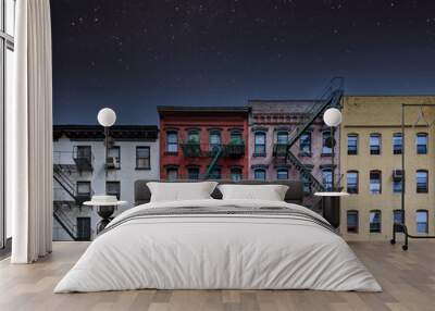 Old colorful New York City apartment buildings with a star filled night sky above Wall mural