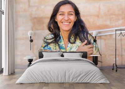 Young indian woman laughing in the street Wall mural