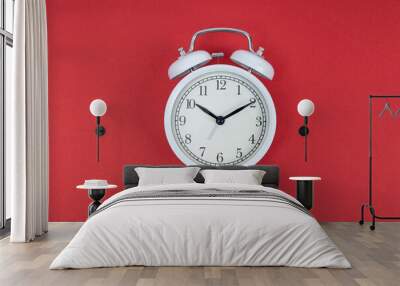 Retro alarm clock on red background. Old fashioned alarm clock Wall mural