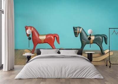 Two vintage rocking horse on wooden floor. Blue and red Wall mural