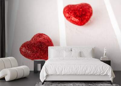 Two glitter red hearts on white wood background. Wall mural