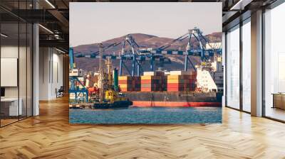 Containers on freight ship in industrial sea port for shipping and logistic, cranes and other special equipment, international commerce delivery concept Wall mural