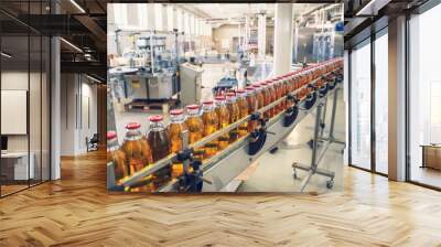 Conveyor belt, juice in glass bottles on beverage plant or factory interior, industrial manufacturing production line Wall mural