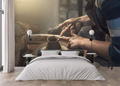 Female potter works with clay on pottery wheel, craftsman hands close up Wall mural