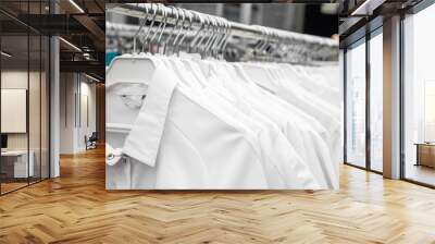 White medical uniform clothes on hangers in store or in hospital Wall mural