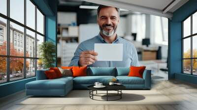 old businessman holding a blank card in his office Wall mural