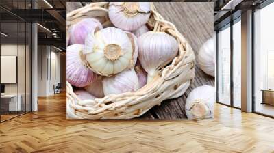 Fresh garlic in a wicker basket on wooden table Wall mural