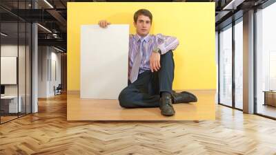 Portrait of a handsome young business man sitting and holding a Wall mural