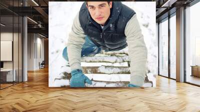 Top view portrait of young handsome man climbing upwards upon wo Wall mural