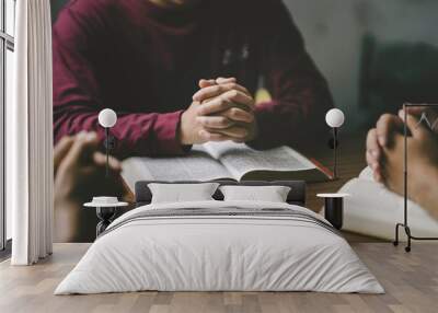 Christian group or family prayer together with a holy bible on a wooden table in church for worship to god in the morning. people pray with faith, Spirituality, and religion concept Wall mural