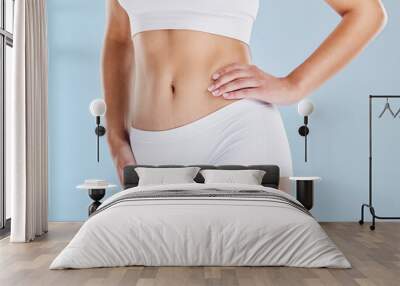 Body, diet and weightloss with a woman in studio on a blue background with her hand on her hip for wellness. Fitness, health and stomach with a model female in underwear for a healthy lifestyle Wall mural