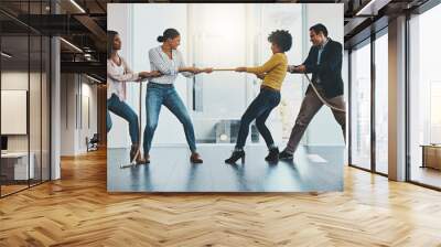 its a competitive market out there with many challenges. shot of a group of businesspeople pulling o Wall mural