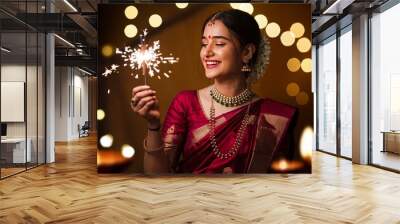 Happy Diwali, Portrait Indian woman celebrating Diwali, the festival of lights, holding a lit diya (oil lamp) in both hands Wall mural