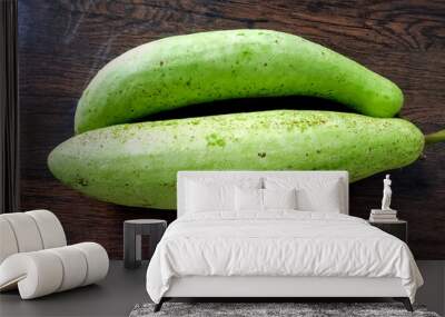 Two green bottle gourd placed on a wooden table Wall mural