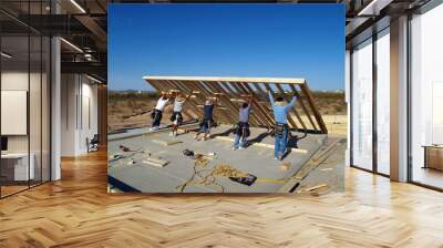 Construction workers lifting a wall frame into position. Wall mural