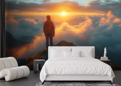 Man on mountain peak with green grass looking at beautiful mountain valley in fog at sunrise in summer. sunset over the mountain Wall mural