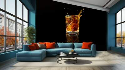 Closeup of whiskey splash in the whiskey glass on black background Wall mural