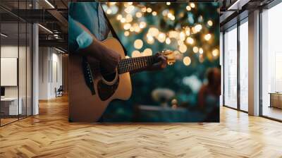 Close-up of a musician playing an acoustic guitar under twinkling string lights during an intimate outdoor evening event Wall mural