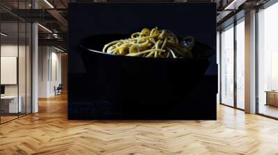 magnificent pasta in a black bowl isolated on a black background, excellent contrast Wall mural