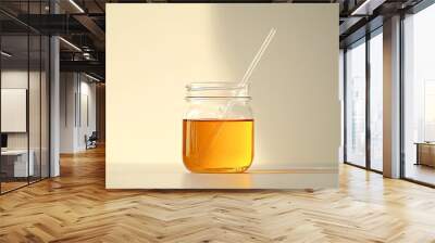 A glass jar filled with amber liquid and two drinking straws, sitting on a white surface with a soft, natural light cast upon it. Wall mural