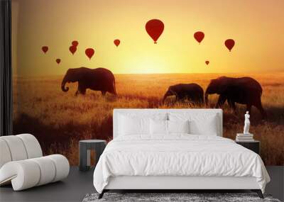 A group of African elephants against the sky with balloons at sunset. African fantastic image. Africa, Tanzania, Serengeti National Park. Summer wonderland. Wall mural