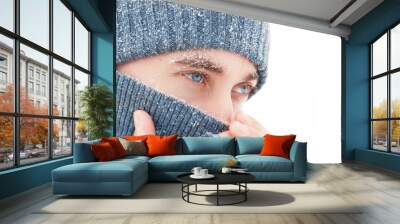 Handsome guy with blue eyes at the snow. Winter portrait. Copy space. Wall mural