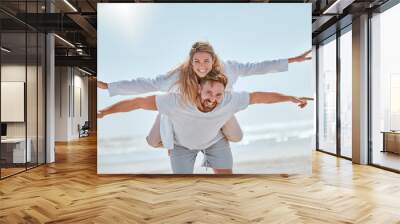 Playful, travel and couple with freedom at the beach for summer love, quality time and holiday in Costa Rica. Nature, flying piggyback and portrait of man and woman at the ocean for marriage vacation Wall mural