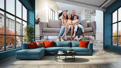 Portrait, love hug and family on sofa in living room, smiling and bonding. Care, support and happy mother, father and girls hugging, embrace or cuddle on couch, having fun and enjoying time together. Wall mural